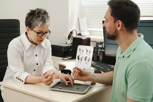 Man getting his hearing aid repaired